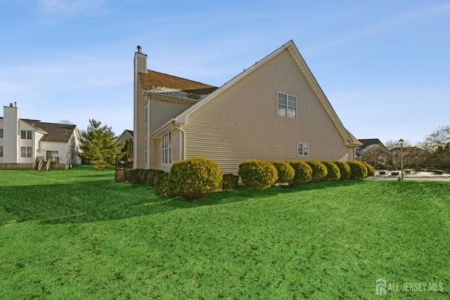 view of side of home with a yard