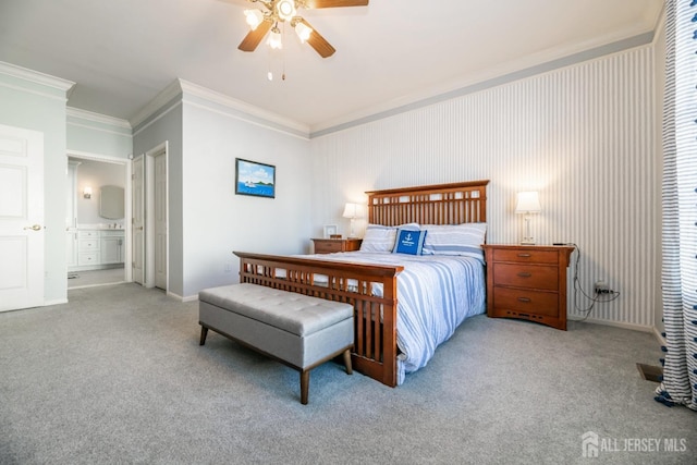 carpeted bedroom with ensuite bathroom, ceiling fan, and crown molding