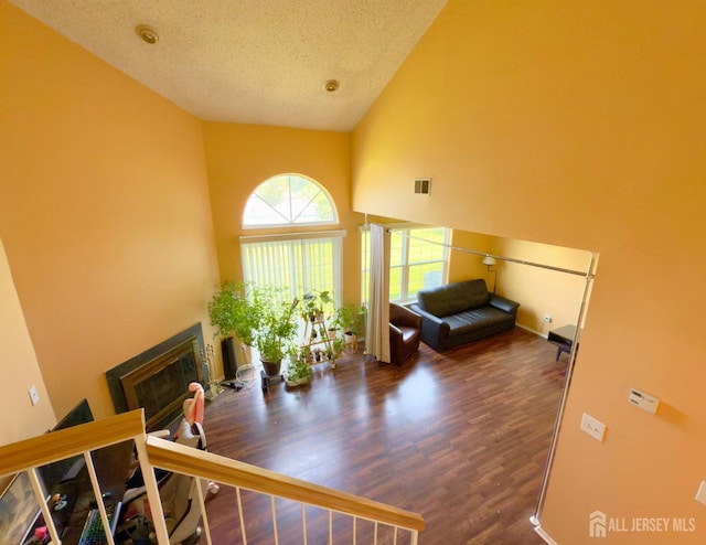 67 Nova Dr, Piscataway, NJ 08854 - living room with a glass covered fireplace, high vaulted ceiling, wood finished floors, a textured ceiling, and baseboards