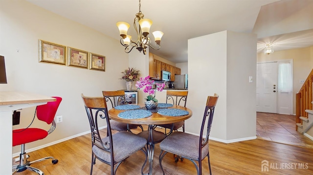 1014 Hemlock Ct, South Brunswick, NJ 08852 - dining room with a chandelier, light wood finished floors, stairs, and baseboards