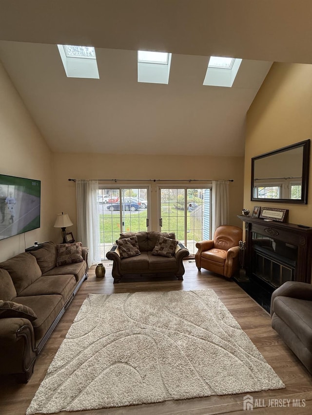 1014 Hemlock Ct, South Brunswick, NJ 08852 - living room featuring a skylight, high vaulted ceiling, plenty of natural light, and wood finished floors