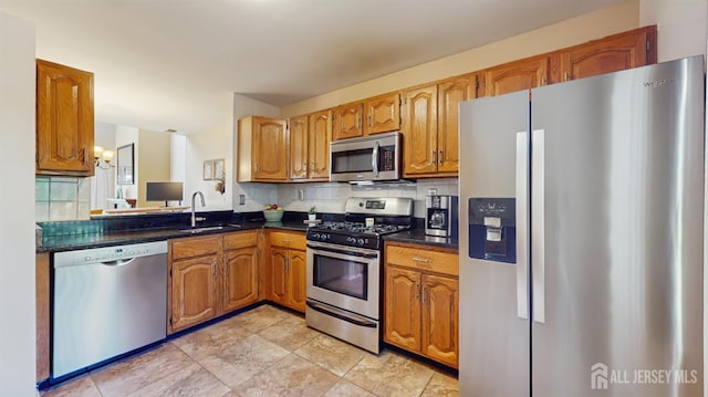 1014 Hemlock Ct, South Brunswick, NJ 08852 - kitchen featuring stainless steel appliances, a sink, dark countertops, tasteful backsplash, and brown cabinets