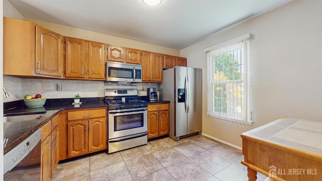 1014 Hemlock Ct, South Brunswick, NJ 08852 - kitchen featuring appliances with stainless steel finishes, brown cabinetry, tasteful backsplash, and baseboards