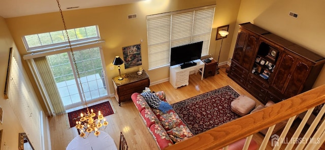 9 Copernicus Ct, East Windsor, NJ 08512 - living room featuring light wood-style flooring, a high ceiling, and a chandelier