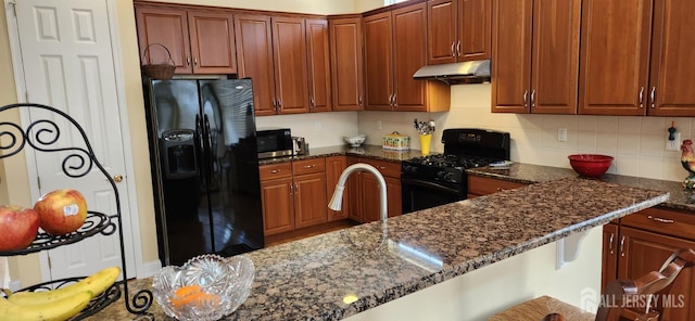 9 Copernicus Ct, East Windsor, NJ 08512 - kitchen with black appliances, under cabinet range hood, dark stone counters, and backsplash