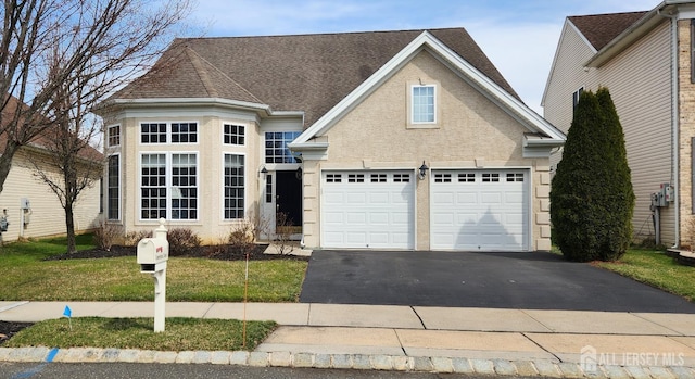 9 Copernicus Ct, East Windsor, NJ 08512 - traditional-style home featuring asphalt driveway, a garage, stucco siding, a front lawn, and a shingled roof