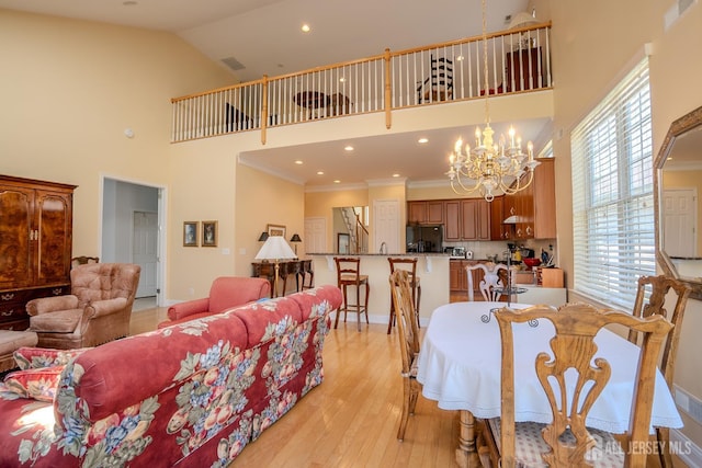 9 Copernicus Ct, East Windsor, NJ 08512 - dining room featuring a towering ceiling, light wood-style floors, a chandelier, healthy amount of natural light, and ornamental molding