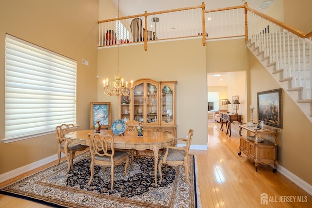 9 Copernicus Ct, East Windsor, NJ 08512 - dining space featuring a high ceiling, a chandelier, light wood-type flooring, and stairs