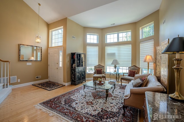 9 Copernicus Ct, East Windsor, NJ 08512 - living room featuring a towering ceiling, stairway, healthy amount of natural light, and wood finished floors