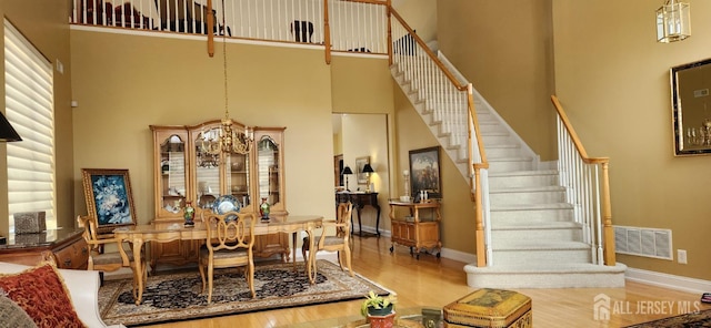 9 Copernicus Ct, East Windsor, NJ 08512 - dining space with a high ceiling, stairs, wood finished floors, and a chandelier