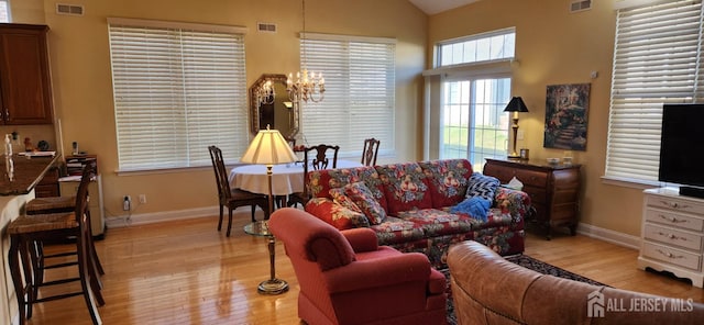 9 Copernicus Ct, East Windsor, NJ 08512 - living room with light wood-style floors, a chandelier, and vaulted ceiling