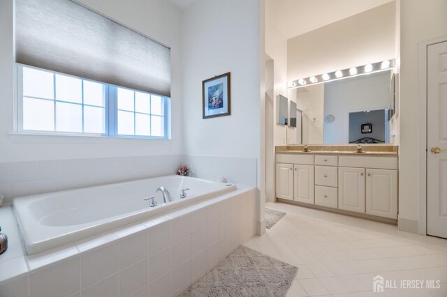 full bathroom featuring a garden tub, double vanity, and tile patterned flooring