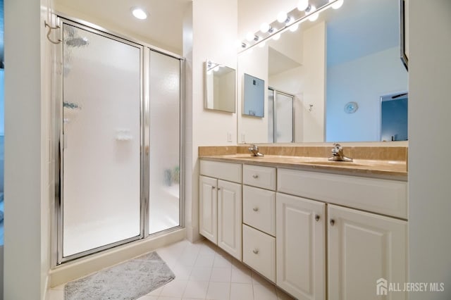 full bath featuring a shower stall, tile patterned flooring, and double vanity