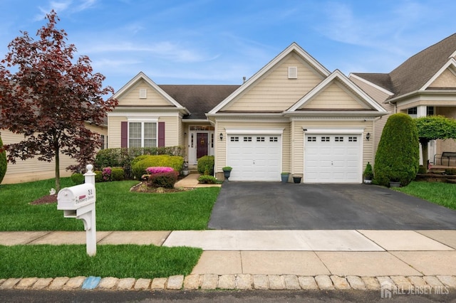 view of front facade featuring driveway, a garage, and a front yard