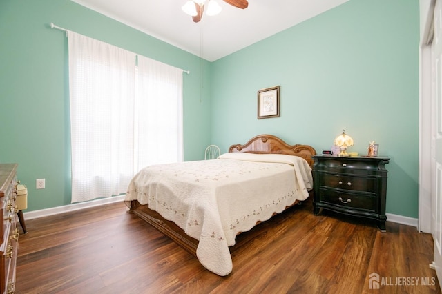 bedroom featuring multiple windows, dark wood-type flooring, and baseboards