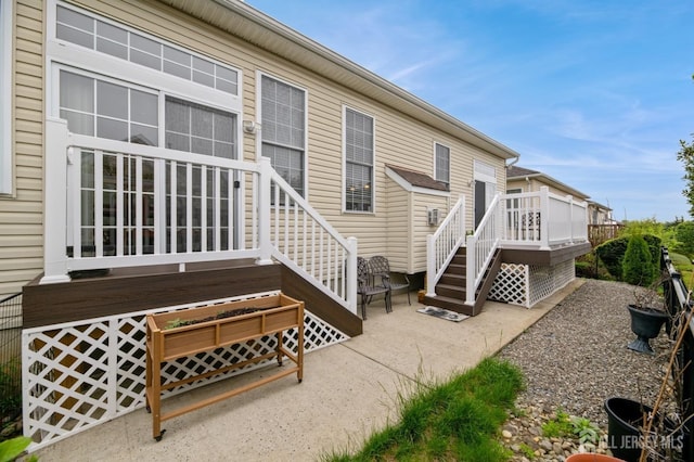 back of property with a wooden deck, stairs, and a patio area