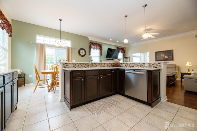kitchen with dishwasher, open floor plan, light countertops, ceiling fan, and ornamental molding