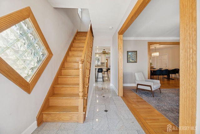 stairs with baseboards, granite floors, and crown molding