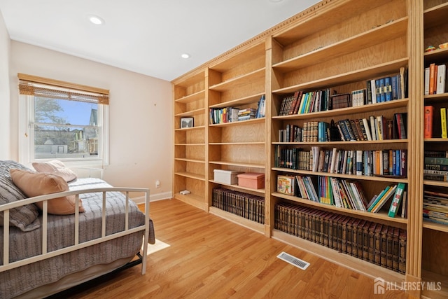 bedroom with wood finished floors, baseboards, and recessed lighting