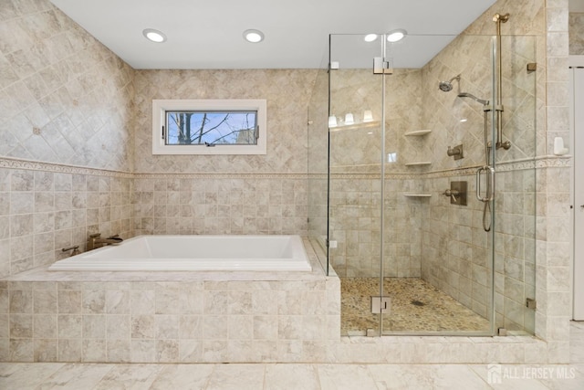 bathroom with a garden tub, a shower stall, and recessed lighting