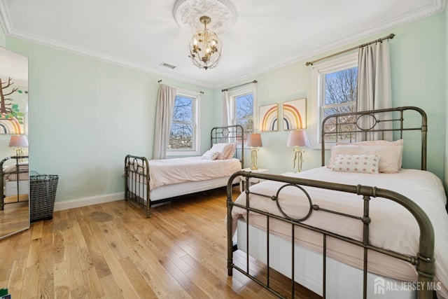 bedroom with crown molding, baseboards, a chandelier, and wood-type flooring