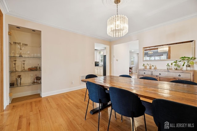 dining area with light wood-type flooring, a chandelier, crown molding, and baseboards