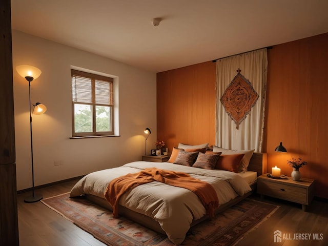 bedroom featuring wood finished floors and wooden walls