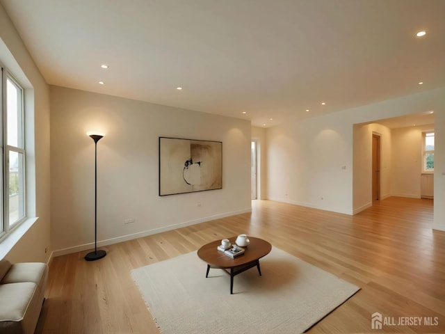 unfurnished living room with baseboards, recessed lighting, and light wood-style floors