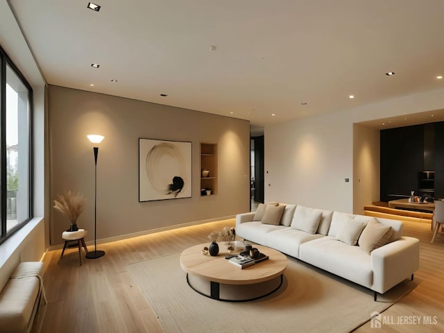 living room with light wood-type flooring, a baseboard radiator, baseboards, and recessed lighting