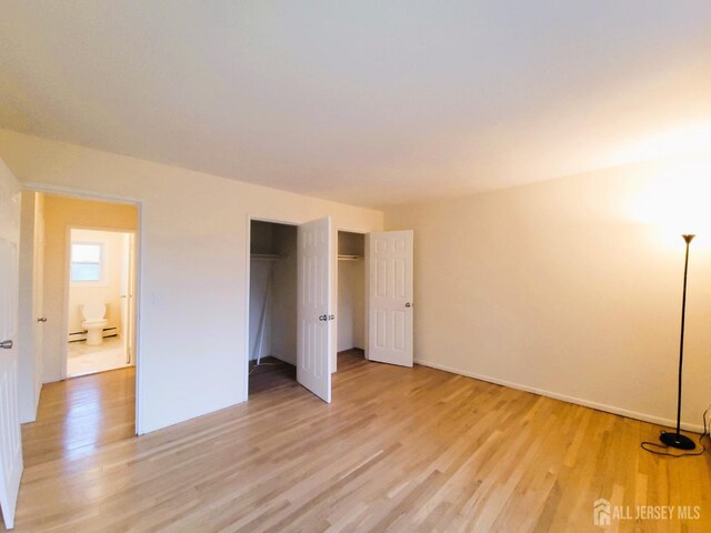 unfurnished bedroom with light wood-style floors and a closet