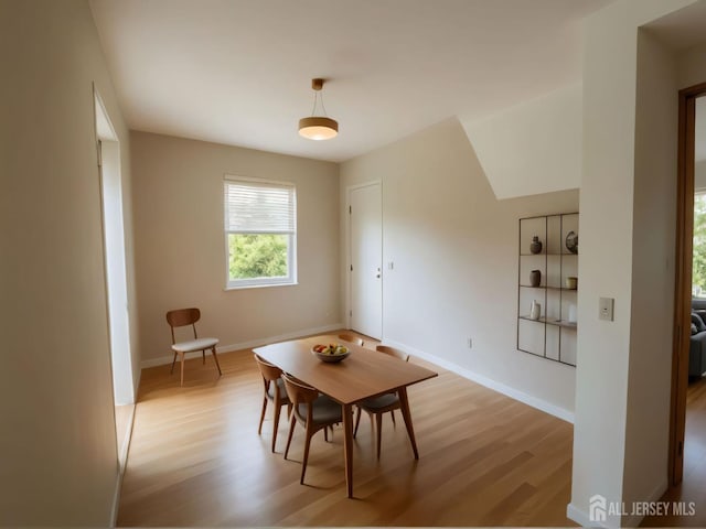 dining room featuring light wood-style flooring and baseboards