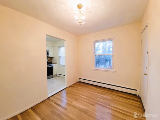 empty room featuring light wood finished floors, baseboards, a baseboard radiator, a baseboard heating unit, and a notable chandelier