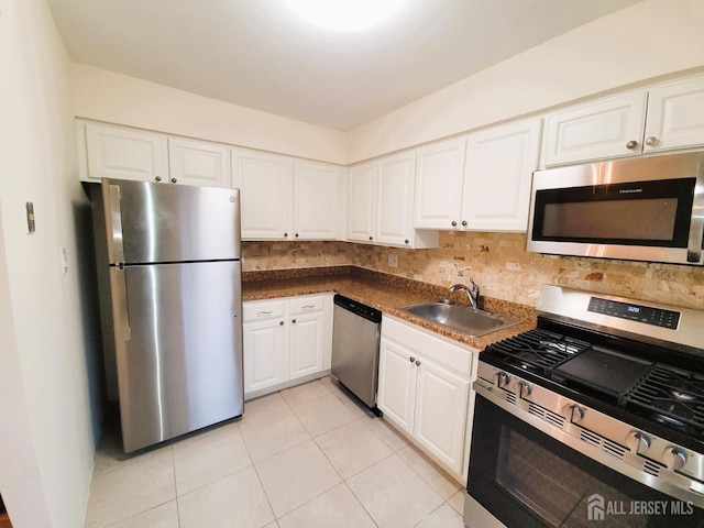 kitchen with appliances with stainless steel finishes, a sink, and white cabinets