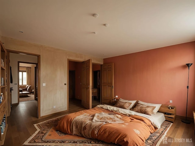 bedroom with wood-type flooring and baseboards