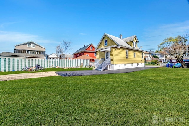 exterior space with fence, a front lawn, and a chimney