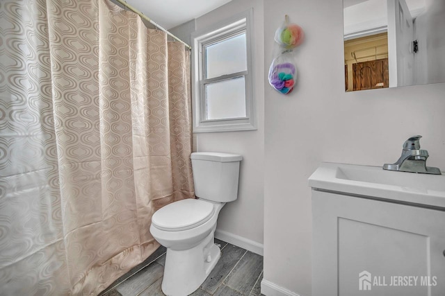 full bath featuring curtained shower, wood finished floors, toilet, vanity, and baseboards