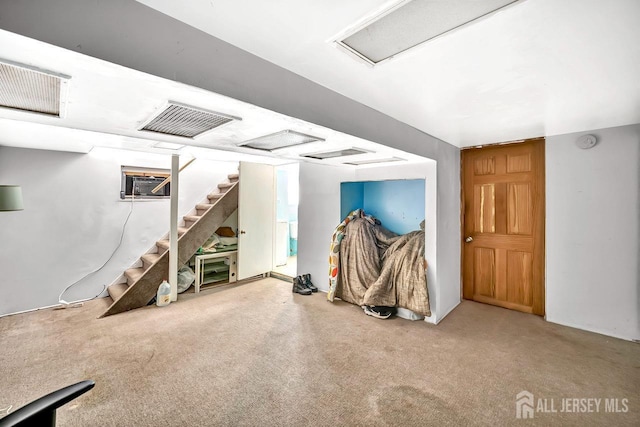 interior space featuring visible vents, carpet flooring, a wall mounted AC, and stairs