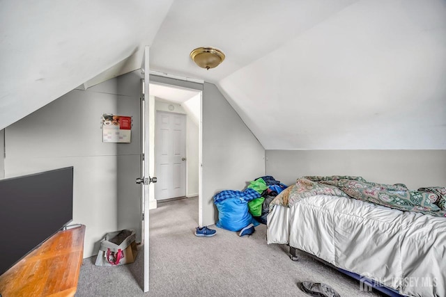 carpeted bedroom with lofted ceiling