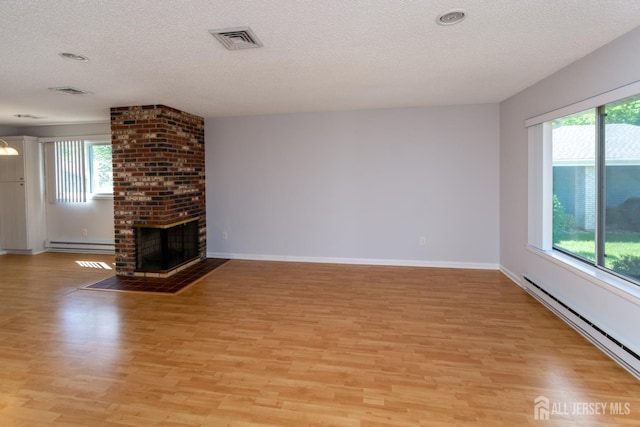 249 Doremus Dr Unit B, Monroe, NJ 08831 - unfurnished living room featuring a baseboard heating unit, light wood-style floors, a textured ceiling, and a fireplace