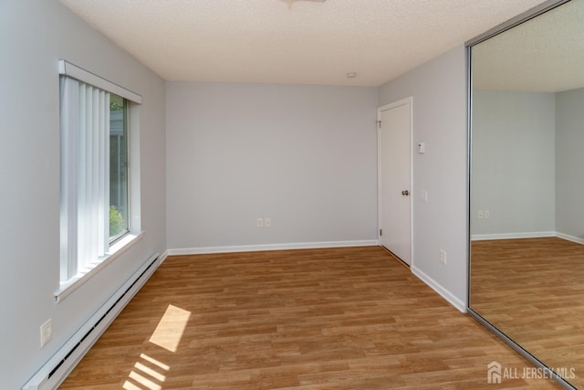 249 Doremus Dr Unit B, Monroe, NJ 08831 - spare room with a baseboard heating unit, plenty of natural light, light wood-type flooring, and a textured ceiling