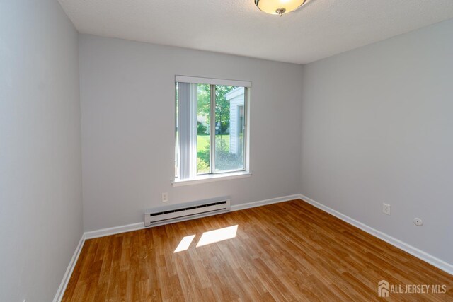 249 Doremus Dr Unit B, Monroe, NJ 08831 - unfurnished room with a baseboard heating unit, light wood-type flooring, and baseboards