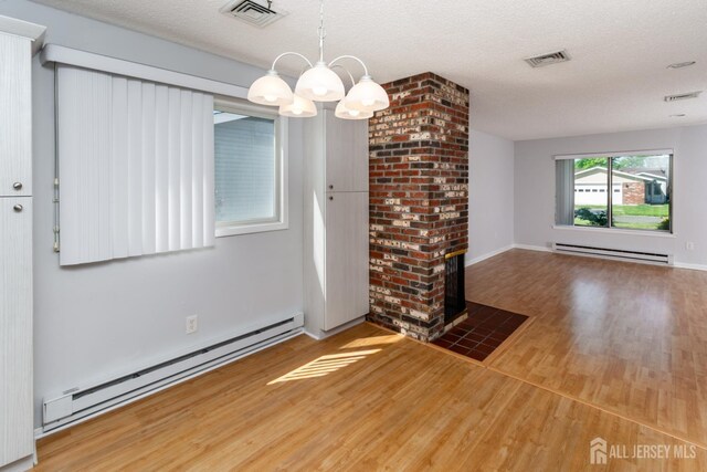 249 Doremus Dr Unit B, Monroe, NJ 08831 - unfurnished dining area featuring a baseboard heating unit, a chandelier, wood finished floors, and a textured ceiling