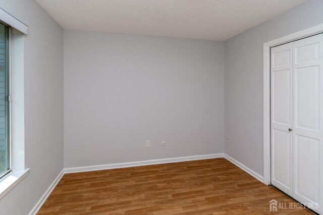 249 Doremus Dr Unit B, Monroe, NJ 08831 - unfurnished bedroom featuring light wood-type flooring, a textured ceiling, baseboards, and a closet