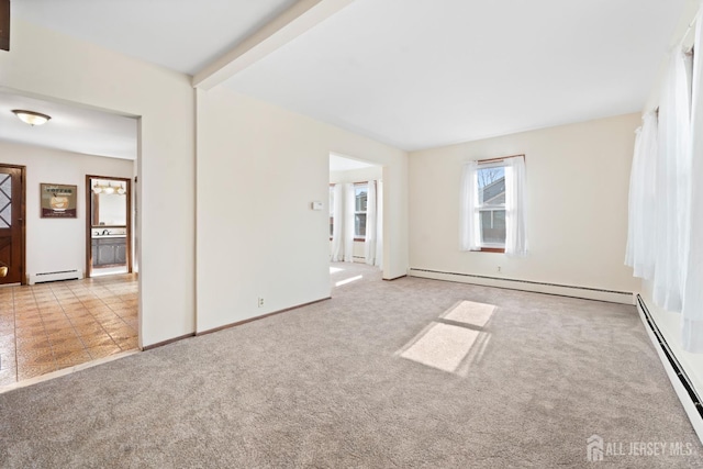 spare room with light carpet, baseboard heating, and beam ceiling