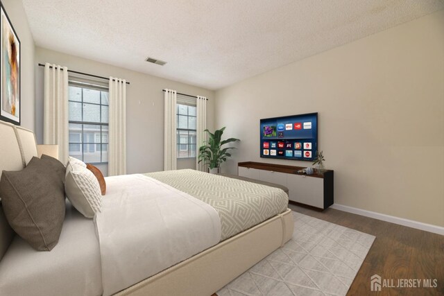 bedroom with hardwood / wood-style floors and a textured ceiling