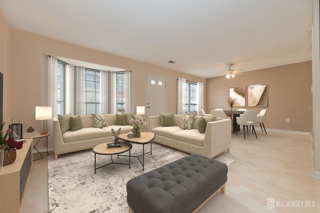 living room with ceiling fan, plenty of natural light, and light hardwood / wood-style floors