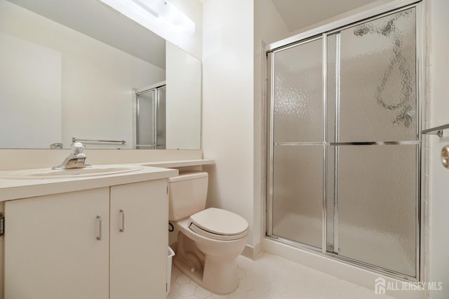 bathroom featuring vanity, tile patterned floors, toilet, and a stall shower