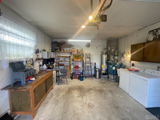 garage featuring independent washer and dryer, a workshop area, a garage door opener, and water heater