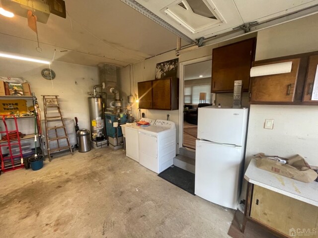 garage with white refrigerator, washing machine and dryer, and water heater