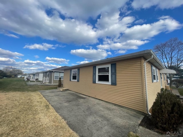 view of side of home with a patio area and a yard